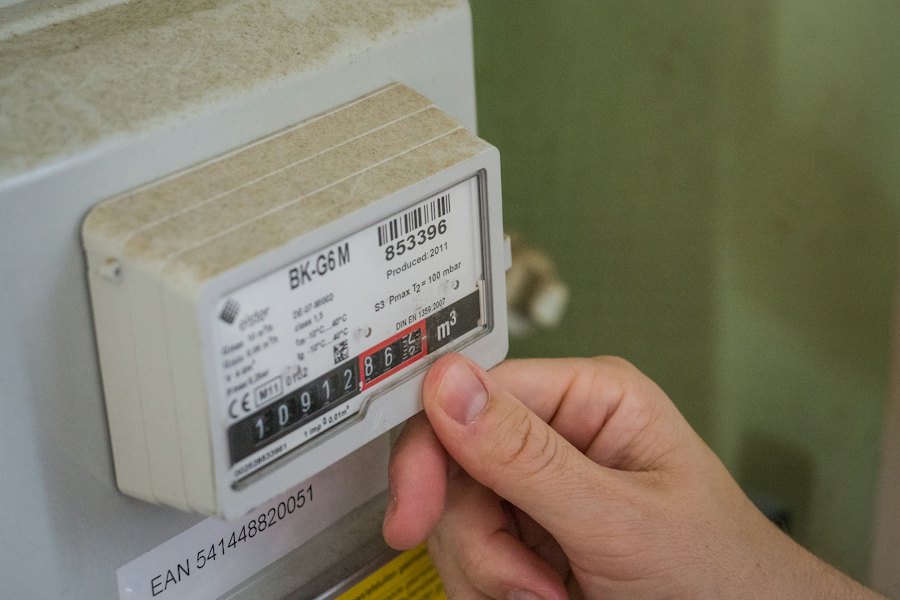 Mano junto a un medidor de energía que mide el consumo eléctrico