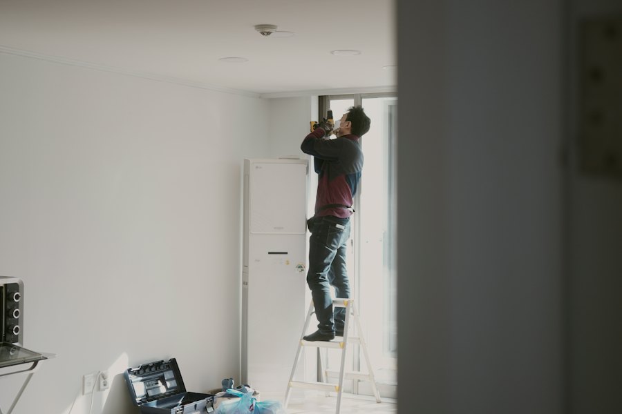 Instalador trabajando en el techo subido a una escalera